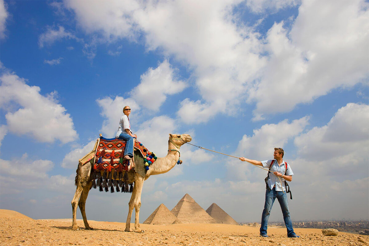 A-foreign-couple-enjoying-a-camel-ride-next-to-the-Three-Pyramids-of-Giza